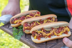 Hot Dog z bekon zawijającą kiełbasą, ketchupem, żółtą musztardą, smażącą cebulą i zalewami, fotografia royalty free Hot Dog z bekon zawijającą kiełbasą, ketchupem, żółtą musztardą, smażącą cebulą i zalewami, fotografia royalty free