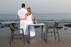 Houdend van paar bij een romantisch diner in het strand stock foto Houdend van paar bij een romantisch diner in het strand stock foto