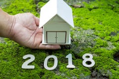 House concepts 2018,Number 2018 with house model on hand with gr Stock Image House concepts 2018,Number 2018 with house model on hand with gr Stock Image
