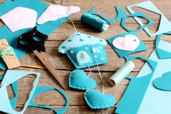 House with hearts decor made from felt, tools and materials for sewing, paper patterns on old wood table. Hanging wall decor Stock Photography House with hearts decor made from felt, tools and materials for sewing, paper patterns on old wood table. Hanging wall decor Stock Photography