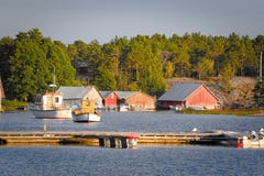 Houten botenhuizen bij zonsondergang in Aland-archipel, waar de aard wordt overdreven stock foto's Houten botenhuizen bij zonsondergang in Aland-archipel, waar de aard wordt overdreven stock foto's