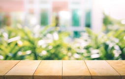 Houten lijstbovenkant bij het onduidelijke beeld van venster met de achtergrond van de tuinbloem royalty-vrije stock fotografie Houten lijstbovenkant bij het onduidelijke beeld van venster met de achtergrond van de tuinbloem royalty-vrije stock fotografie