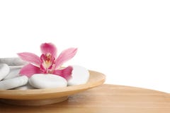 Houten plaat met van het orchideebloem en kuuroord rotsen op lijst tegen witte achtergrond royalty-vrije stock afbeeldingen Houten plaat met van het orchideebloem en kuuroord rotsen op lijst tegen witte achtergrond royalty-vrije stock afbeeldingen