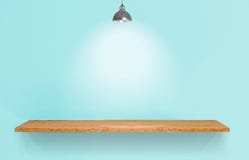 Houten plank met lamp op blauwe uitstekende muur stock afbeeldingen Houten plank met lamp op blauwe uitstekende muur stock afbeeldingen