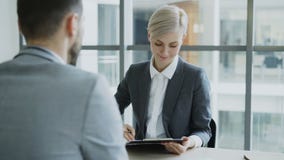 HR bizneswoman ma akcydensowego wywiad z młodym człowiekiem w kostiumu i ogląda jego życiorysu zastosowanie w nowożytnym biurze HR bizneswoman ma akcydensowego wywiad z młodym człowiekiem w kostiumu i ogląda jego życiorysu zastosowanie w nowożytnym biurze