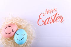 Huevos azules y rosados con sonrisas pintadas en la jerarquía, espacio de la copia Diseño feliz de la tarjeta de felicitación del imagen de archivo libre de regalías Huevos azules y rosados con sonrisas pintadas en la jerarquía, espacio de la copia Diseño feliz de la tarjeta de felicitación del imagen de archivo libre de regalías