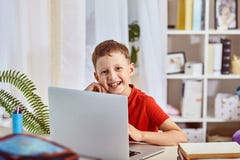 Huis het scholen, onderzoek en studie, nieuwe kennis gelukkig kind bij de lijst met de computer weinig zitting van de jongensstud royalty-vrije stock afbeeldingen Huis het scholen, onderzoek en studie, nieuwe kennis gelukkig kind bij de lijst met de computer weinig zitting van de jongensstud royalty-vrije stock afbeeldingen