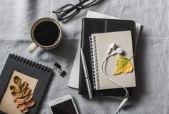 Huiswerkplaats met zaken, onderwijs, onderwijstoebehoren Blocnote, tablet, telefoon, earbuds, pen, glazen, koffie op grijze bedel stock afbeelding Huiswerkplaats met zaken, onderwijs, onderwijstoebehoren Blocnote, tablet, telefoon, earbuds, pen, glazen, koffie op grijze bedel stock afbeelding
