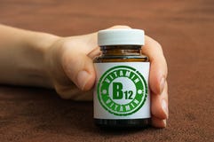 Human hand holding a bottle of pills with vitamin B12 stock photos Human hand holding a bottle of pills with vitamin B12 stock photos
