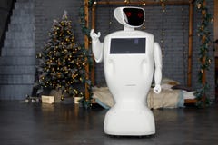 The robot meets Christmas, stands on the background of the garland royalty free stock images The robot meets Christmas, stands on the background of the garland royalty free stock images