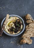 Hummus caramelizado balsâmico da cebola e baguette da semente do trigo inteiro multi em um fundo escuro fotos de stock Hummus caramelizado balsâmico da cebola e baguette da semente do trigo inteiro multi em um fundo escuro fotos de stock