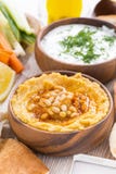 Hummus i träbunke med pitabröd och nya grönsaker royaltyfri bild Hummus i träbunke med pitabröd och nya grönsaker royaltyfri bild