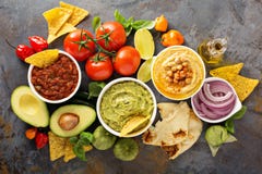 Hummus, salsa e guacamole casalinghi con i chip di cereale Fotografie Stock Hummus, salsa e guacamole casalinghi con i chip di cereale Fotografie Stock