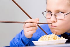 Hungry Boy Eating Chinese Noodles With Sticks Stock Photos