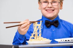 Hungry Boy Eating Chinese Noodles With Sticks Royalty Free Stock Photography