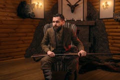 Hunter man with old gun against antique chest stock photo Hunter man with old gun against antique chest stock photo