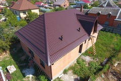 Hus med ett nytt metalltak Taket av det korrugerade arket Taklägga av krabb form för metallprofil arkivbilder Hus med ett nytt metalltak Taket av det korrugerade arket Taklägga av krabb form för metallprofil arkivbilder