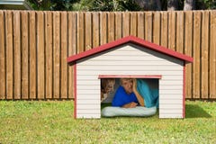 Husband or boyfriend man sleeping in the doghouse because of domestic problems Royalty Free Stock Image Husband or boyfriend man sleeping in the doghouse because of domestic problems Royalty Free Stock Image