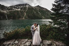 Huwelijkspaar het kussen dichtbij het meer in Tatra-bergen in Polen Morskie Oko De mooie Dag van de Zomer royalty-vrije stock afbeeldingen Huwelijkspaar het kussen dichtbij het meer in Tatra-bergen in Polen Morskie Oko De mooie Dag van de Zomer royalty-vrije stock afbeeldingen