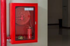 Hydranten med bevattnar vattnar med slang och avfyrar sl?cker utrustning Brands?kerhetsutrustning i den r?da asken p? v?ggcement royaltyfri bild Hydranten med bevattnar vattnar med slang och avfyrar sl?cker utrustning Brands?kerhetsutrustning i den r?da asken p? v?ggcement royaltyfri bild