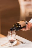 Hällande rött vin för uppassare royaltyfria foton Hällande rött vin för uppassare royaltyfria foton