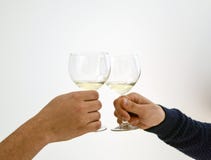Händer som rostar klirra exponeringsglas för vitt vin arkivfoton Händer som rostar klirra exponeringsglas för vitt vin arkivfoton