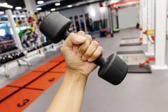 Händer som rymmer hantlar i sportklubba arkivfoton Händer som rymmer hantlar i sportklubba arkivfoton