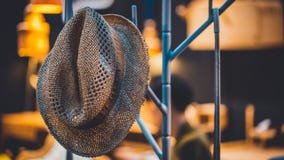 Hängender Brown-Hut auf Metallgestell lizenzfreies stockfoto Hängender Brown-Hut auf Metallgestell lizenzfreies stockfoto