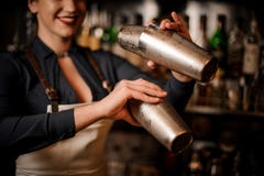 Härlig le kvinnlig bartenderdanandecoctail i shaker royaltyfri fotografi Härlig le kvinnlig bartenderdanandecoctail i shaker royaltyfri fotografi