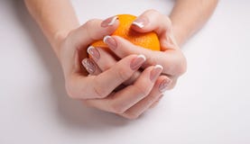 härlig manicure Kvinnliga händer rymmer en apelsin royaltyfri fotografi härlig manicure Kvinnliga händer rymmer en apelsin royaltyfri fotografi