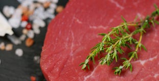 Härlig saftig biff för nytt kött på en tabell med salt, rosmarin, vitlök och tomaten på en svart bakgrund, bästa sikt Begrepp: fr arkivfoton Härlig saftig biff för nytt kött på en tabell med salt, rosmarin, vitlök och tomaten på en svart bakgrund, bästa sikt Begrepp: fr arkivfoton