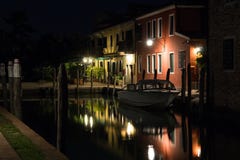 Härlig tyst aftoncityscape av den Burano ön i Venedig Färgade byggnader exponeras av gataljus reflekterade i en wa royaltyfri foto Härlig tyst aftoncityscape av den Burano ön i Venedig Färgade byggnader exponeras av gataljus reflekterade i en wa royaltyfri foto