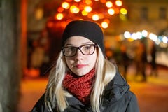 Härlig ung flicka i exponeringsglas på natten som poserar mot bakgrunden av nattljus Blondinen i en svart hatt ler arkivfoton Härlig ung flicka i exponeringsglas på natten som poserar mot bakgrunden av nattljus Blondinen i en svart hatt ler arkivfoton