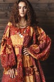 Härlig ung kvinna med den långa lockiga frisyren, modesmycken med brunetthår Indisk stilkläder, lång klänning arkivfoton Härlig ung kvinna med den långa lockiga frisyren, modesmycken med brunetthår Indisk stilkläder, lång klänning arkivfoton