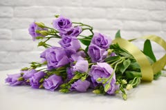 Härlig älskvärd lila eustoma med ett satängband på den vita tabellen arkivfoton Härlig älskvärd lila eustoma med ett satängband på den vita tabellen arkivfoton