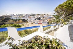 Härliga Carvoeiro med färgrika hus vid den breda sandiga stranden arkivbilder Härliga Carvoeiro med färgrika hus vid den breda sandiga stranden arkivbilder