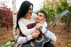 Härliga par som är förälskade på naturen med en gitarr royaltyfria bilder Härliga par som är förälskade på naturen med en gitarr royaltyfria bilder