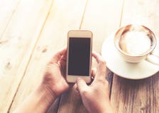 härliga unga händer för hipsterkvinna` som s rymmer den smarta telefonen för mobilen med den varma kaffekoppen på kafét, shoppar royaltyfria bilder härliga unga händer för hipsterkvinna` som s rymmer den smarta telefonen för mobilen med den varma kaffekoppen på kafét, shoppar royaltyfria bilder