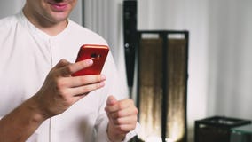 Härligt glat bruk en cell- smartphone, medan sitta i vardagsrummet i aftonen le barn för lycklig man stock video Härligt glat bruk en cell- smartphone, medan sitta i vardagsrummet i aftonen le barn för lycklig man stock video