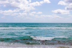 Härligt hav med vågor och turkosvatten för molnig himmel på stranden på en sommardag royaltyfria foton Härligt hav med vågor och turkosvatten för molnig himmel på stranden på en sommardag royaltyfria foton