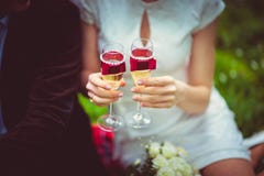 Hållande champagneexponeringsglas för brud som dekoreras med purpurfärgade satängband och pärlor, ferie av brudarna royaltyfri bild Hållande champagneexponeringsglas för brud som dekoreras med purpurfärgade satängband och pärlor, ferie av brudarna royaltyfri bild