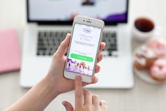 Hållande iPhone 6S Rose Gold för kvinna med Viber på skärmen arkivfoton Hållande iPhone 6S Rose Gold för kvinna med Viber på skärmen arkivfoton