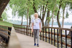 hög kvinna i sportswear som går på träbanan arkivfoton hög kvinna i sportswear som går på träbanan arkivfoton