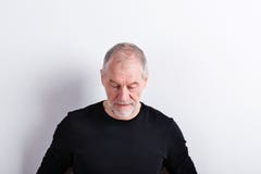 Hög man i den svarta t-skjortan som ner ser, studioskott arkivbilder Hög man i den svarta t-skjortan som ner ser, studioskott arkivbilder
