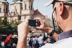 Hög man som tar foto på kamera i den gamla stadfyrkanten, Prague, Tjeckien royaltyfri foto Hög man som tar foto på kamera i den gamla stadfyrkanten, Prague, Tjeckien royaltyfri foto