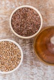 Hölzerne Schüsseln mit Flachs und Weizenkorn und -öl Stockfotos Hölzerne Schüsseln mit Flachs und Weizenkorn und -öl Stockfotos