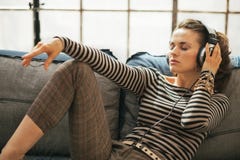 Hörende Musik der jungen Frau in den Kopfhörern stockfoto Hörende Musik der jungen Frau in den Kopfhörern stockfoto