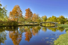Höstlandskap med flodbron och guld- trädreflexion fotografering för bildbyråer Höstlandskap med flodbron och guld- trädreflexion fotografering för bildbyråer