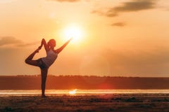 Hübsche Frau, die draußen Yoga bei Sonnenuntergang tut Lizenzfreie Stockfotos Hübsche Frau, die draußen Yoga bei Sonnenuntergang tut Lizenzfreie Stockfotos