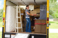 Hübsche Frau, die einen vollen beweglichen LKW lädt lizenzfreie stockbilder Hübsche Frau, die einen vollen beweglichen LKW lädt lizenzfreie stockbilder